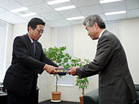 申請書を渡すアッカ社長の木村氏（右）と、受領する関東総合通信局長の江嵜氏